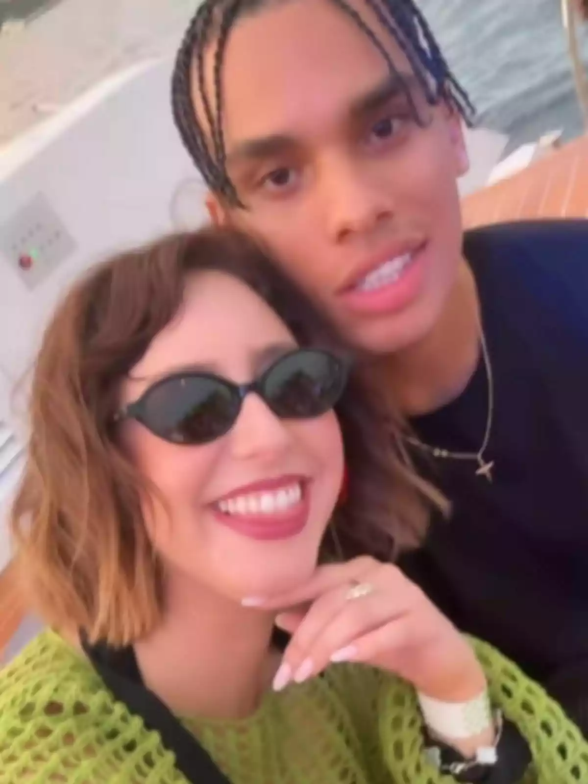 Jazmin Grimaldi and Alexandre Grimaldi smile for a selfie outdoors near the water. Jazmin Grimaldi and Alexandre Grimaldi smile for a selfie outdoors near the water.