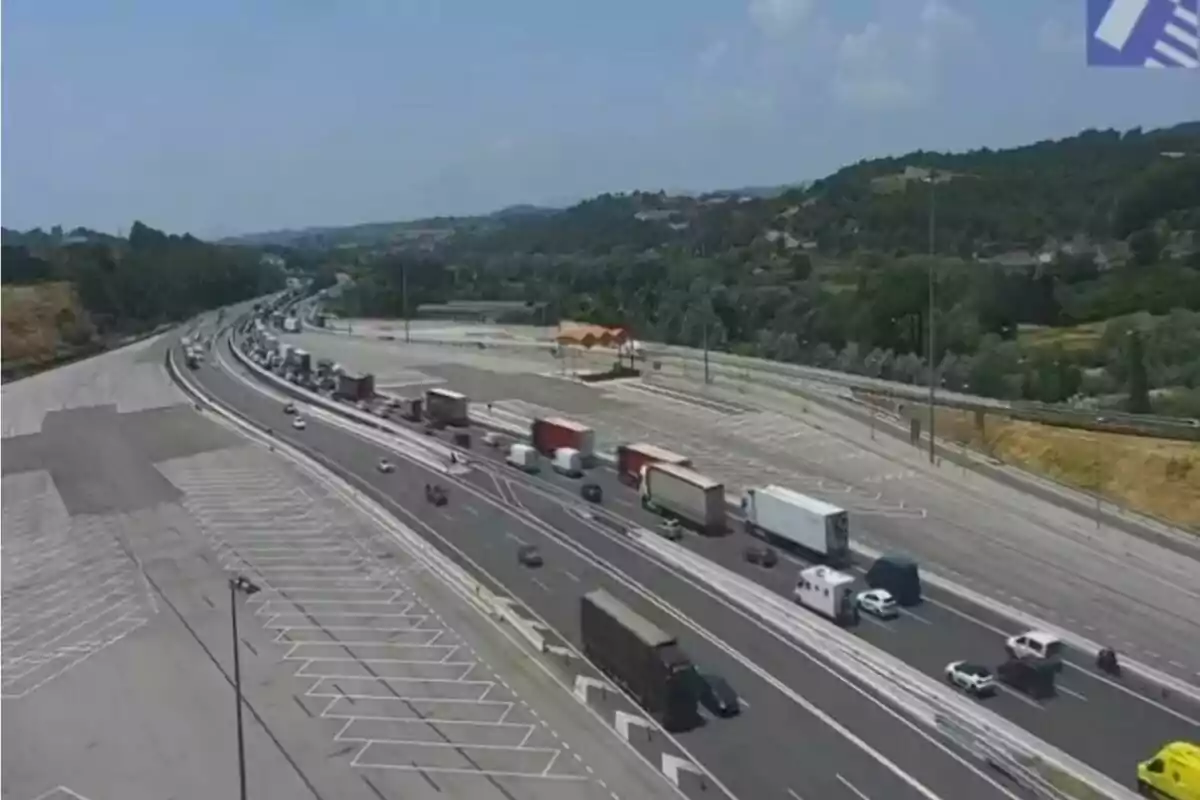 Tráfico de camiones y autos en una autopista con paisaje de colinas y cielo despejado