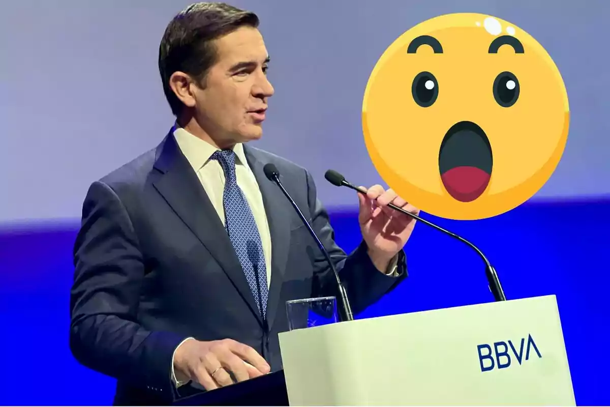 Home amb vestit parlant en un faristol de BBVA amb un emoji de sorpresa gran sobre la imatge