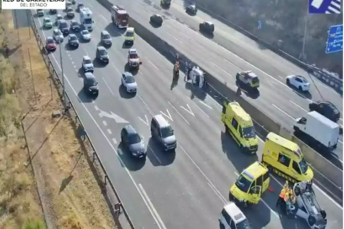 Accident de trànsit en una autopista amb diversos vehicles d’emergència atenent la situació i un cotxe bolcat al carril dret