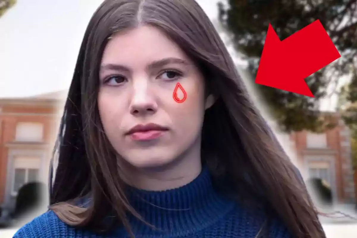 Joven de cabello largo y suelto con suéter azul, una lágrima dibujada en la mejilla y una flecha roja señalando su rostro