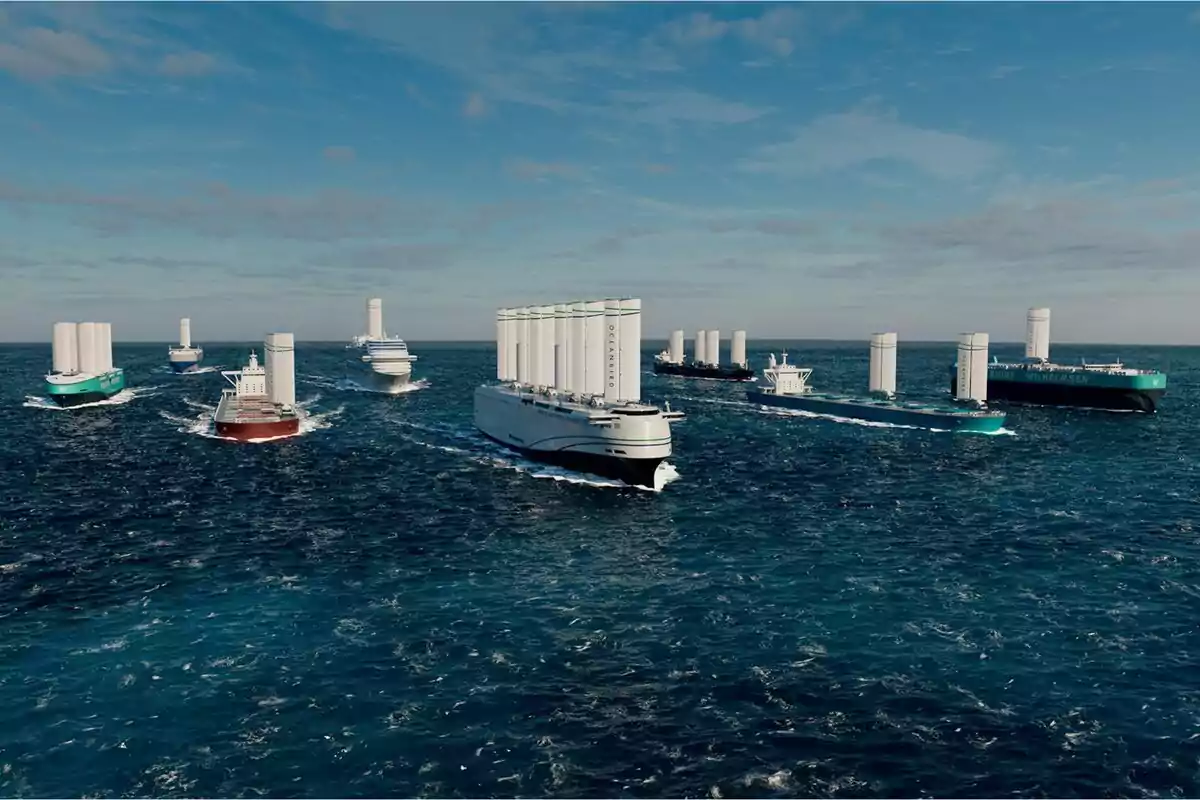 Diversos vaixells moderns naveguen pel mar equipats amb grans veles cilíndriques blanques sota un cel parcialment ennuvolat. Diversos vaixells moderns naveguen pel mar equipats amb grans veles cilíndriques blanques sota un cel parcialment ennuvolat.