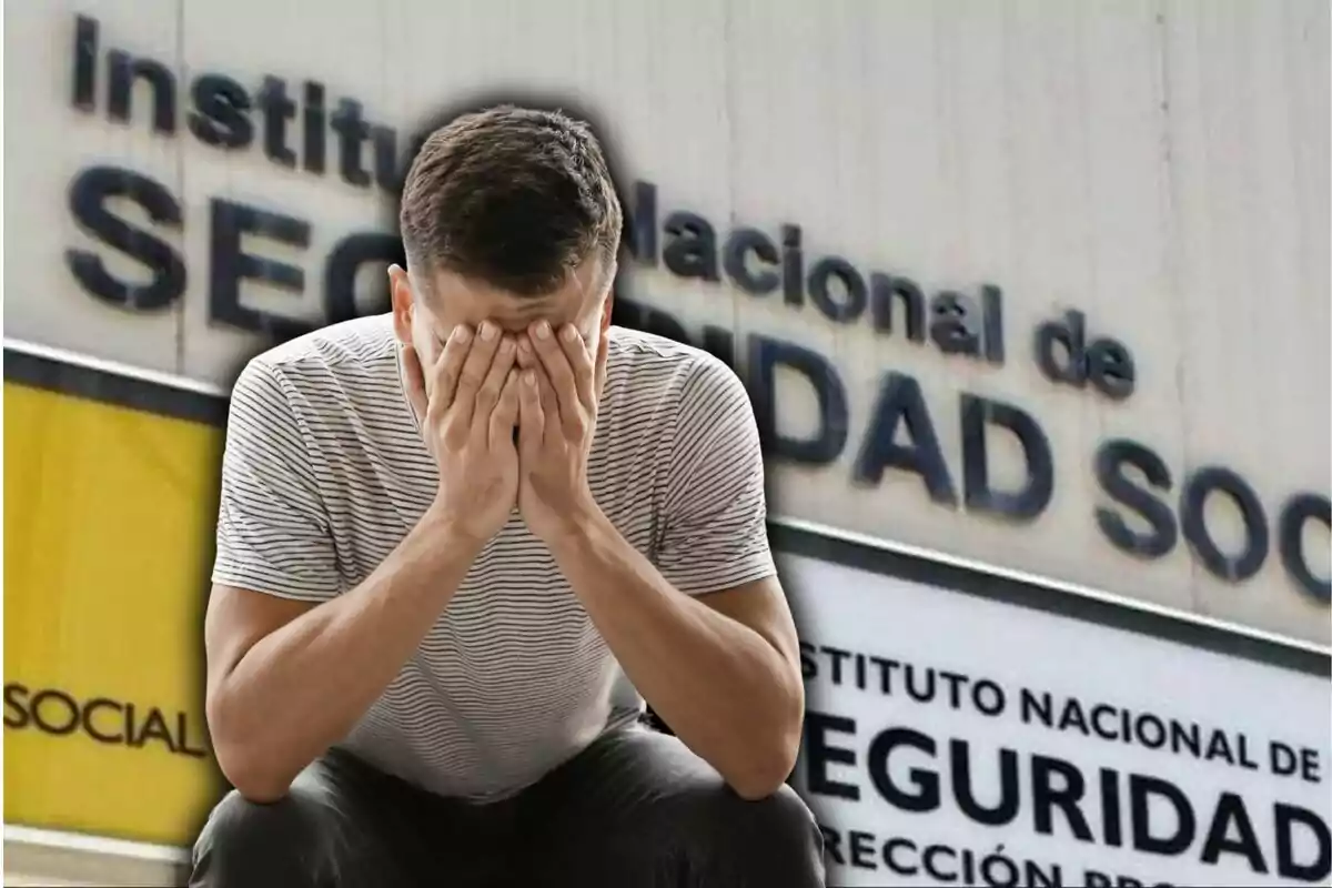 Home assegut amb les mans a la cara davant de cartells de l'Institut Nacional de la Seguretat Social
