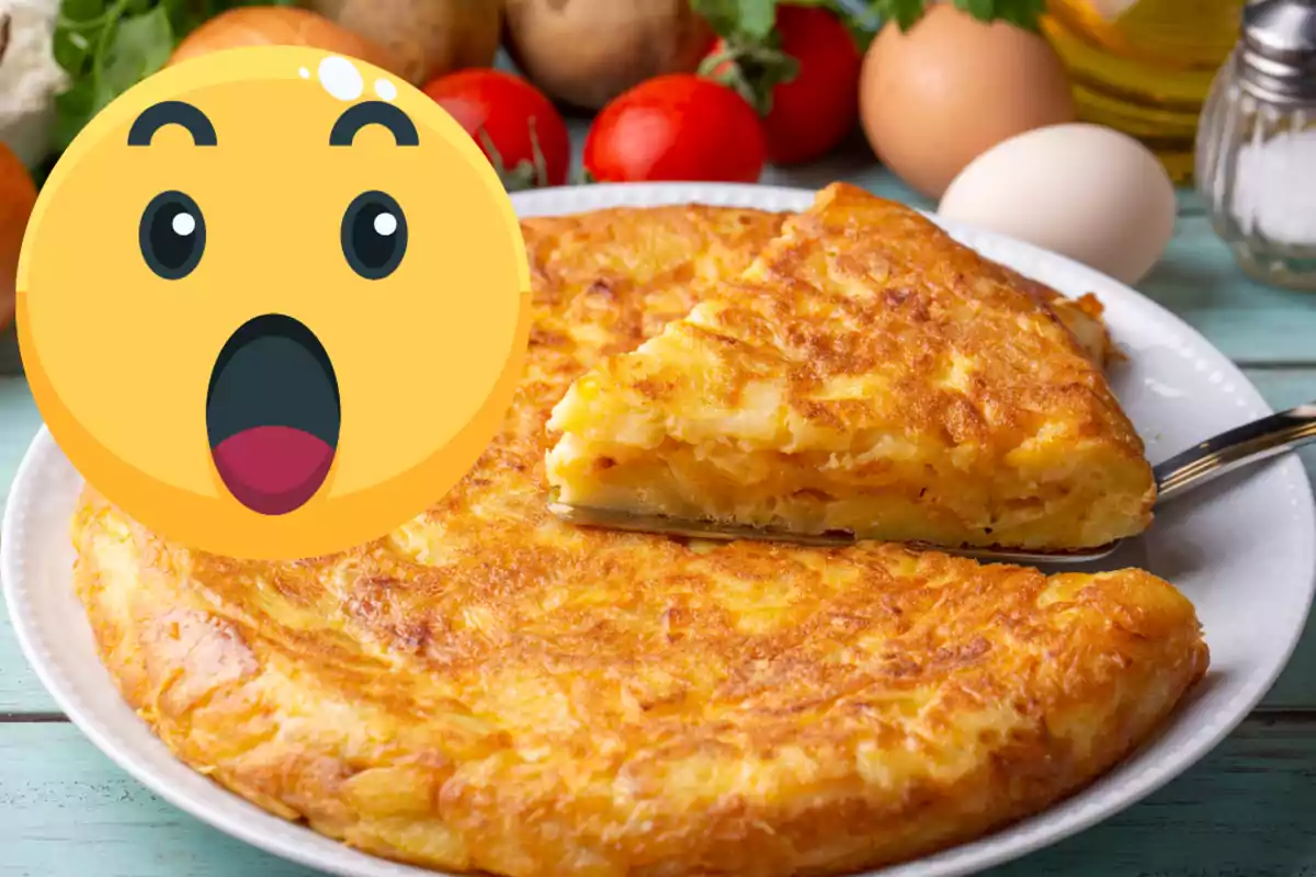 Truita de patates en un plat amb un emoji de sorpresa cobrint part de la imatge i alguns ingredients al fons