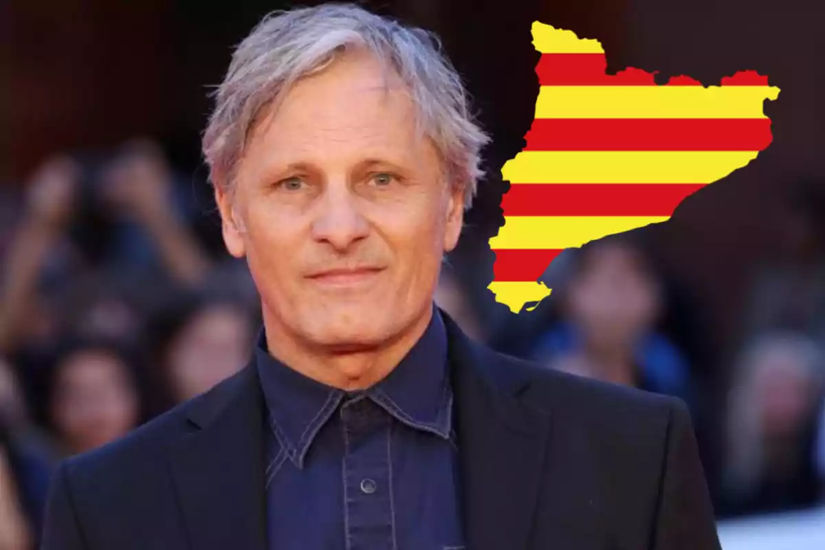 Home de cabells canosos amb un fons de persones desenfocades i un mapa de Catalunya amb franges vermelles i grogues al seu costat