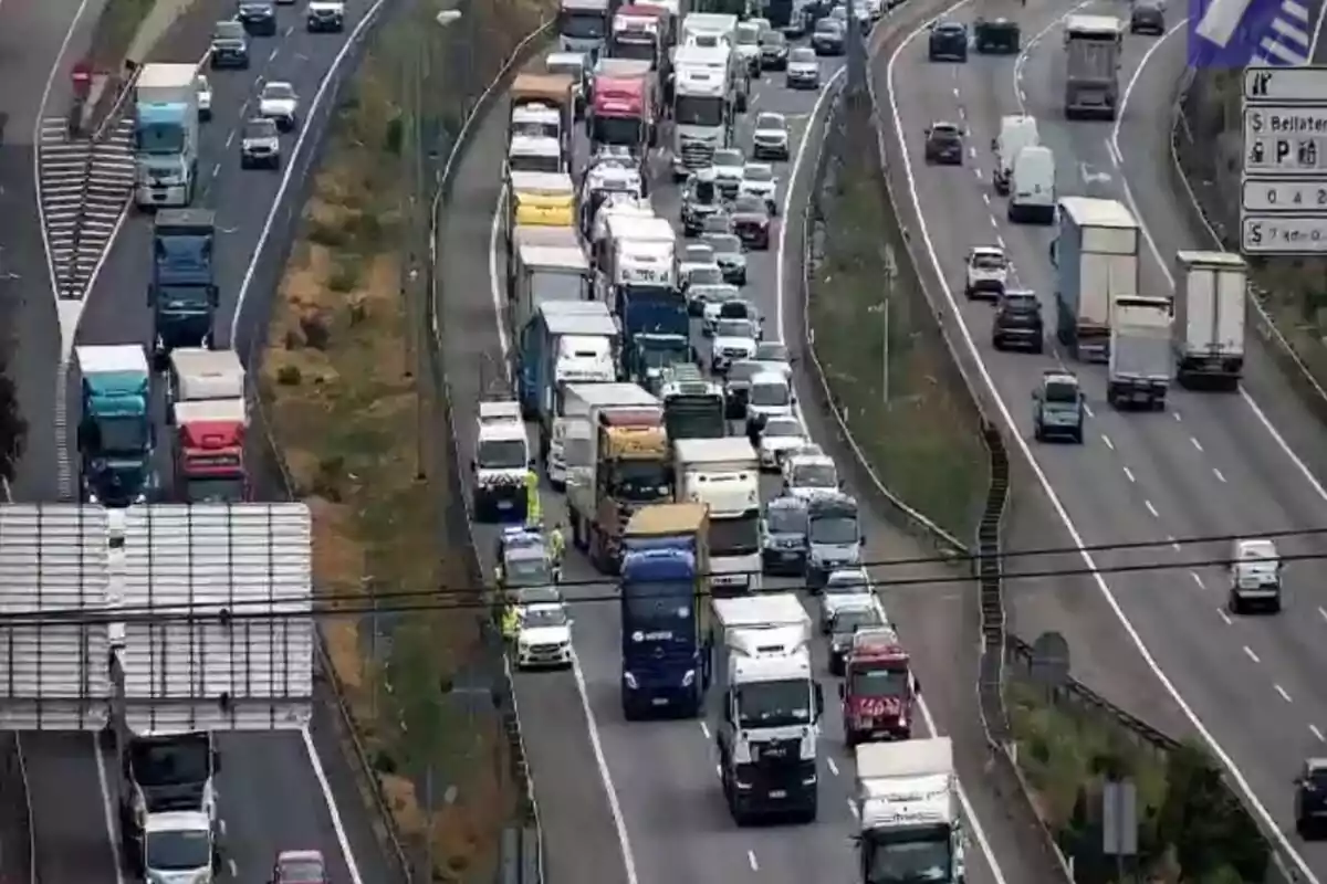 Trànsit dens amb nombrosos camions i cotxes aturats en una autopista de diversos carrils