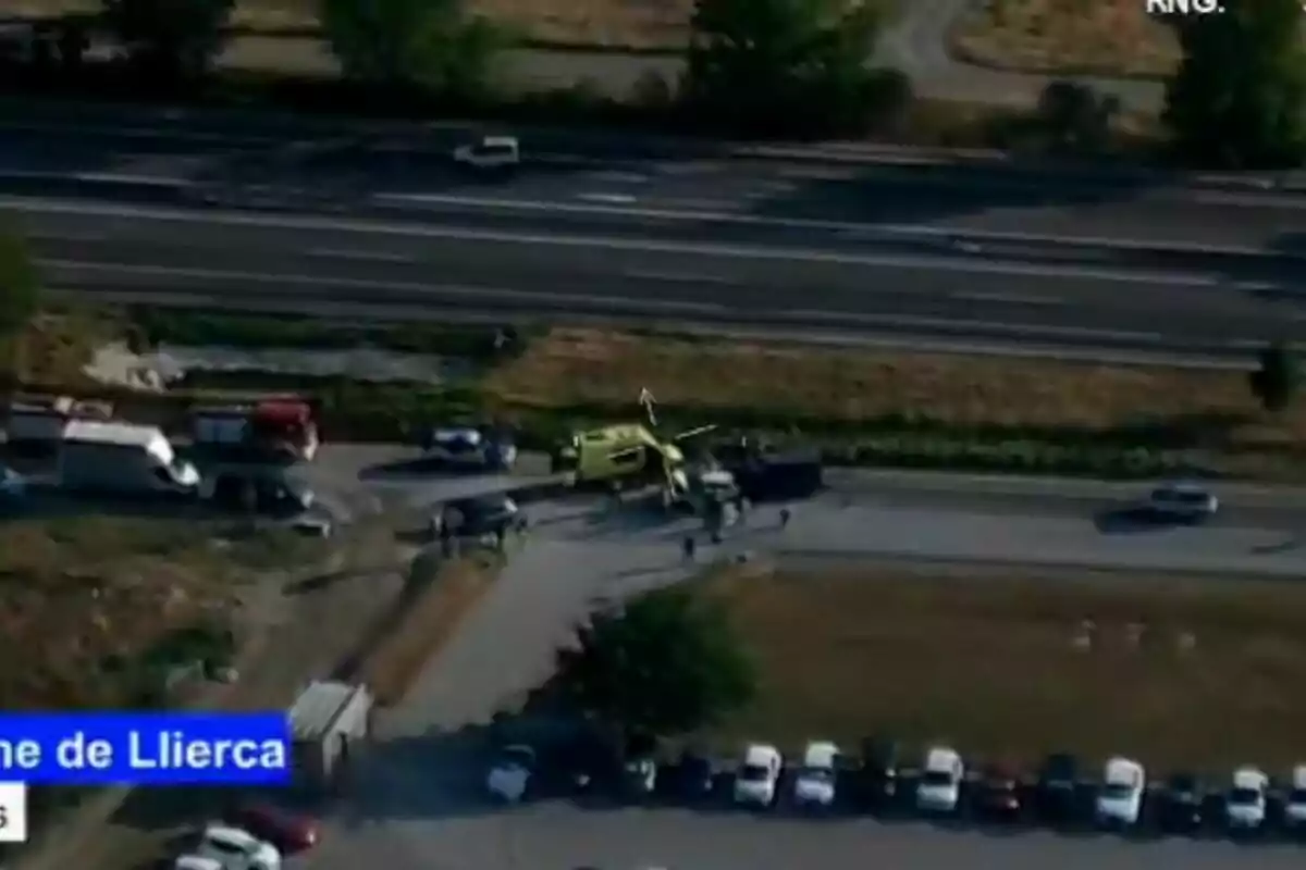Vista aèria d’un operatiu d’emergència amb ambulància, helicòpter i diversos vehicles a prop d’una carretera