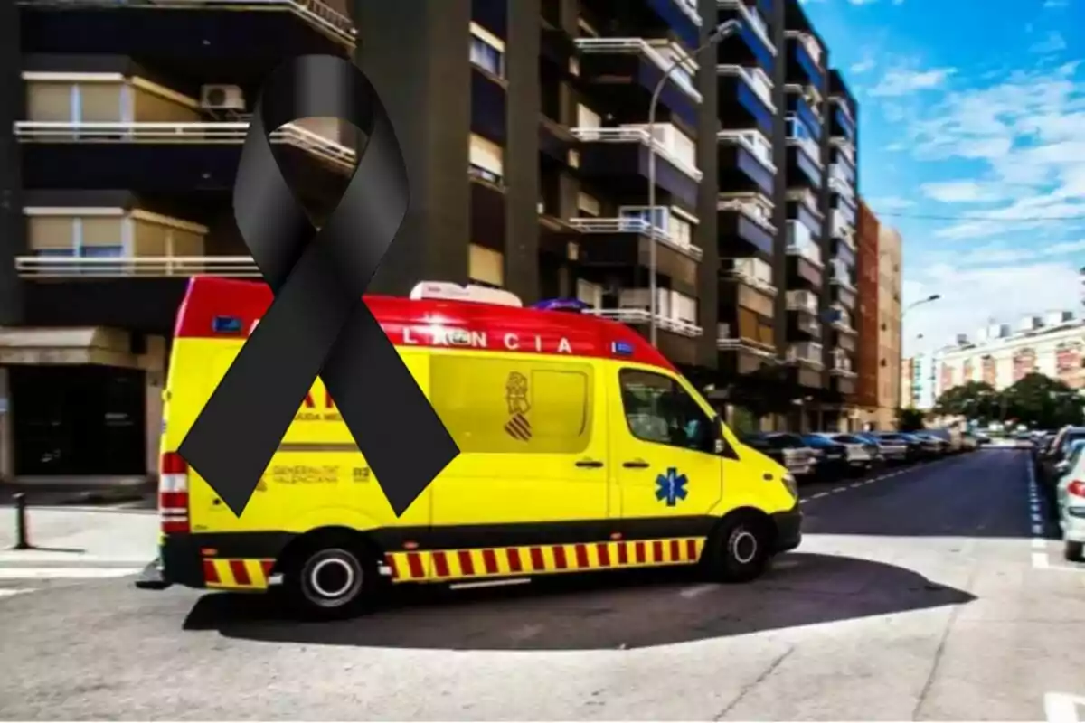 Ambulància groga estacionada en un carrer urbà amb un llaç negre de dol superposat a la imatge