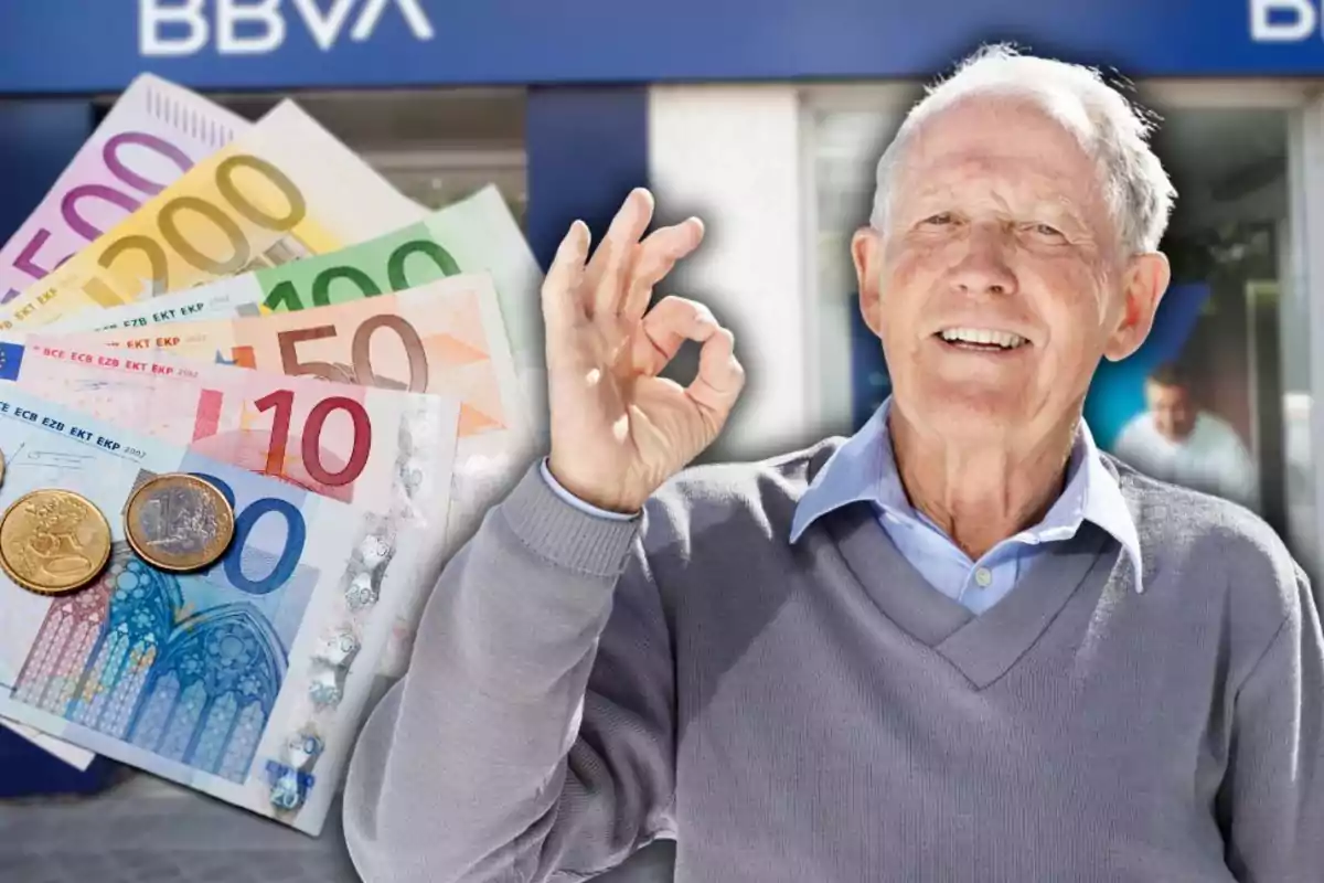 Hombre mayor sonriente haciendo un gesto de aprobación con la mano frente a un banco y billetes de euro Hombre mayor sonriente haciendo un gesto de aprobación con la mano frente a un banco y billetes de euro