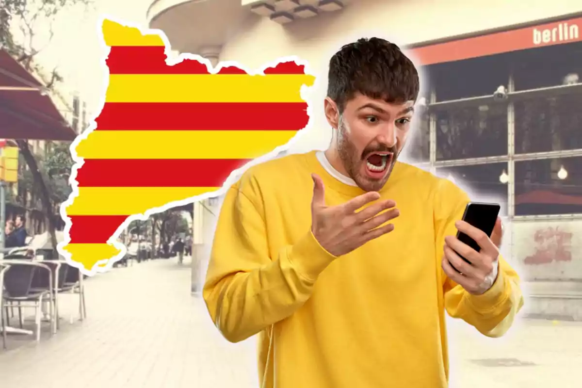 Home sorprès mirant el seu telèfon mòbil amb el fons d’un carrer i la silueta de Catalunya amb la bandera catalana