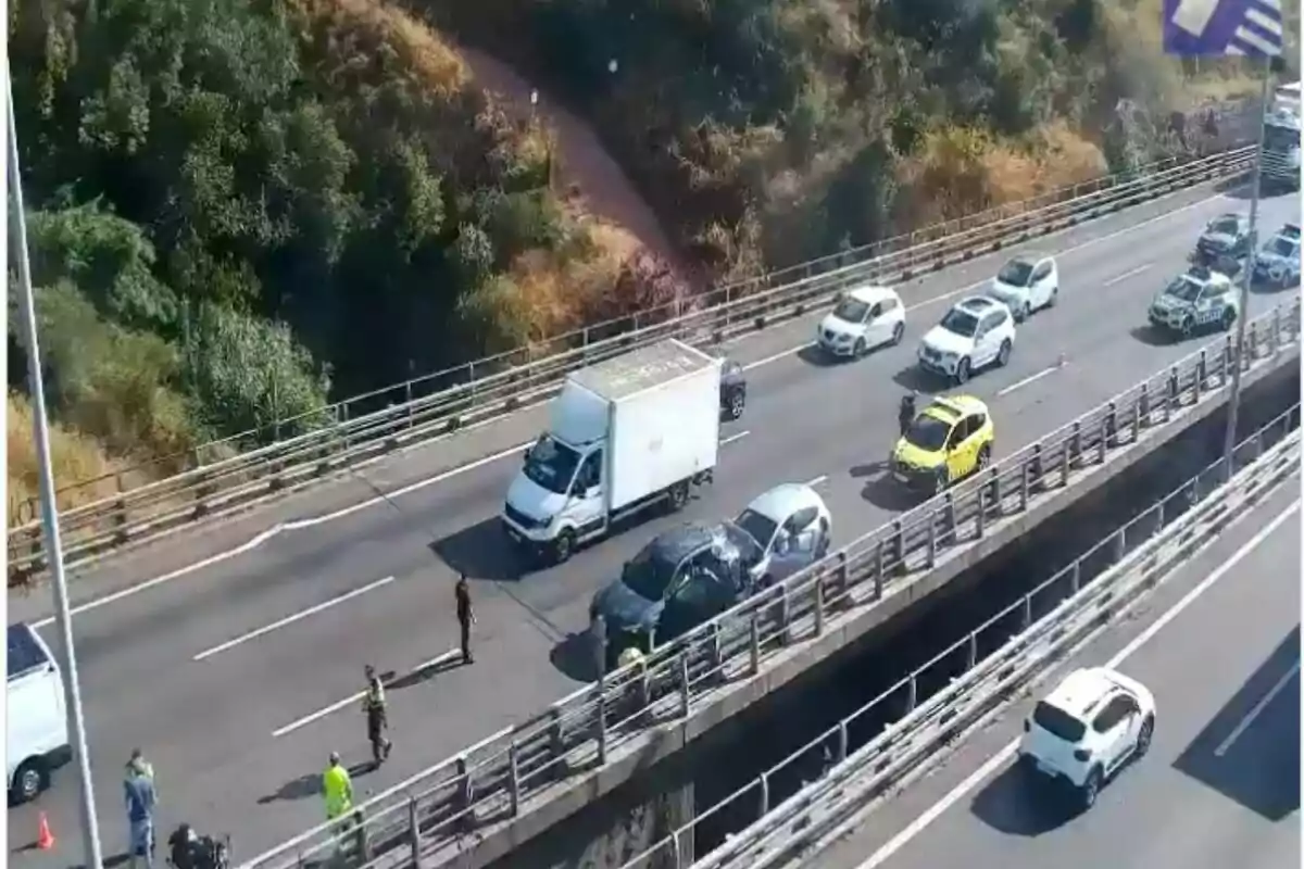 Vista aèria d’un accident de trànsit en una autopista amb diversos vehicles aturats i personal d’emergència atenent la situació