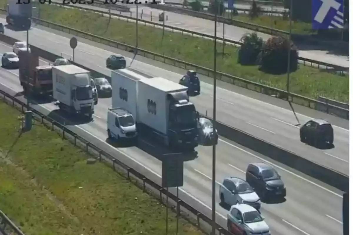 Tráfico en una autopista con varios autos y camiones circulando en diferentes carriles bajo luz solar