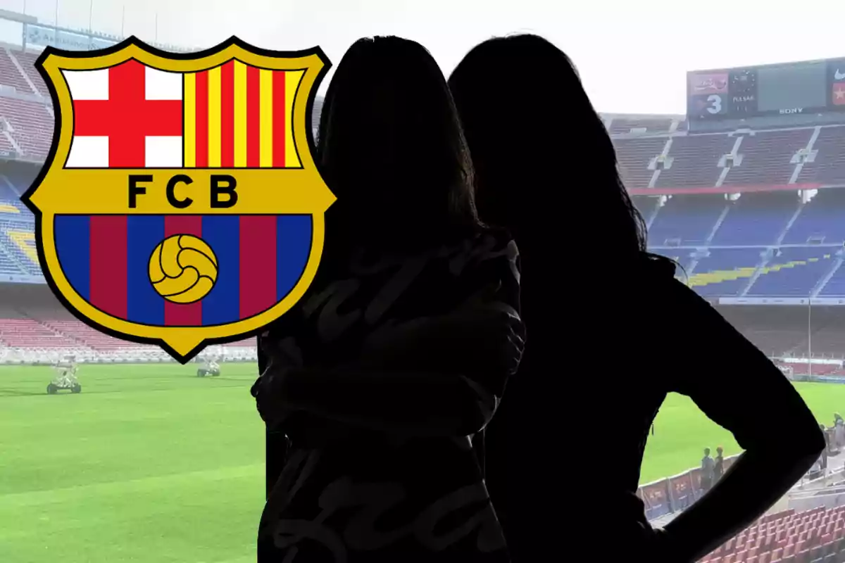 Dues figures femenines en silueta davant de les grades d’un estadi amb l’escut del FC Barcelona en primer pla