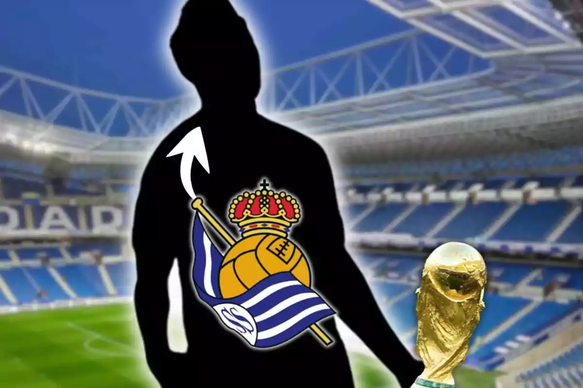 Silueta de una persona con el escudo de la Real Sociedad en el pecho, una flecha blanca apuntando hacia arriba y el trofeo de la Copa del Mundo en primer plano dentro de un estadio de fútbol.
