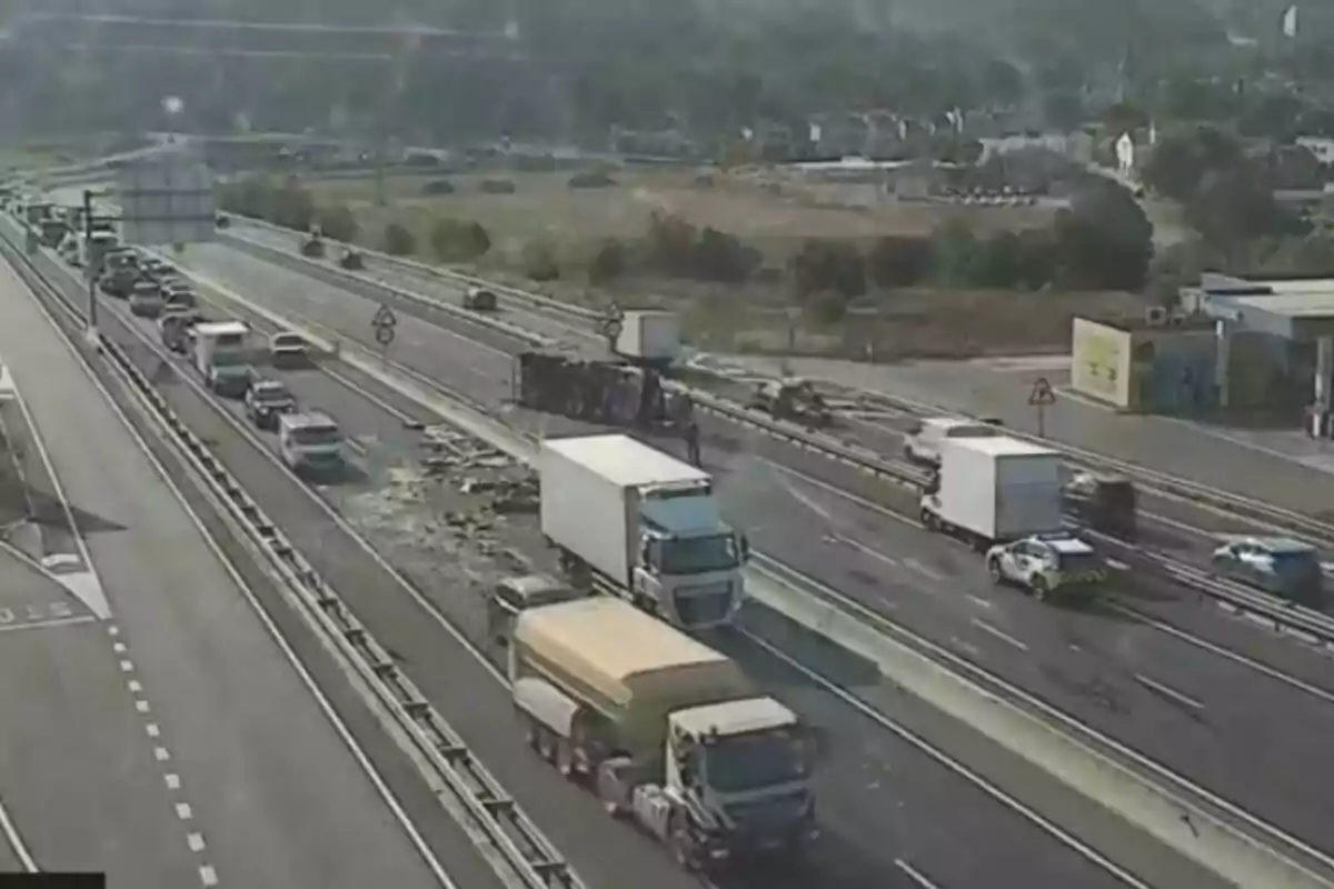 Accident de camió bolcat en una autopista amb trànsit aturat i presència policial