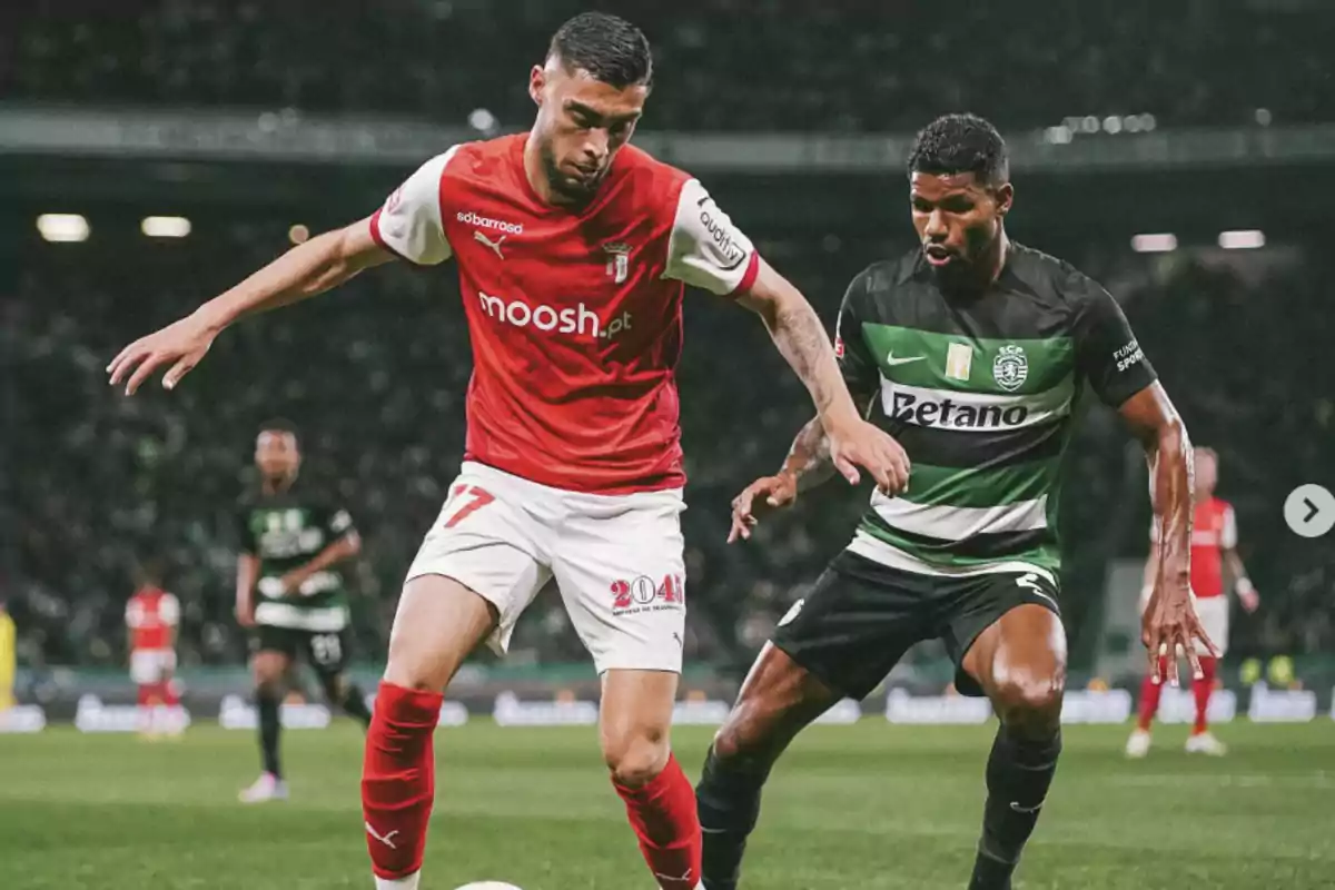 Two players compete for the ball during a match between Braga and Sporting Lisbon in a packed stadium. Two players compete for the ball during a match between Braga and Sporting Lisbon in a packed stadium.