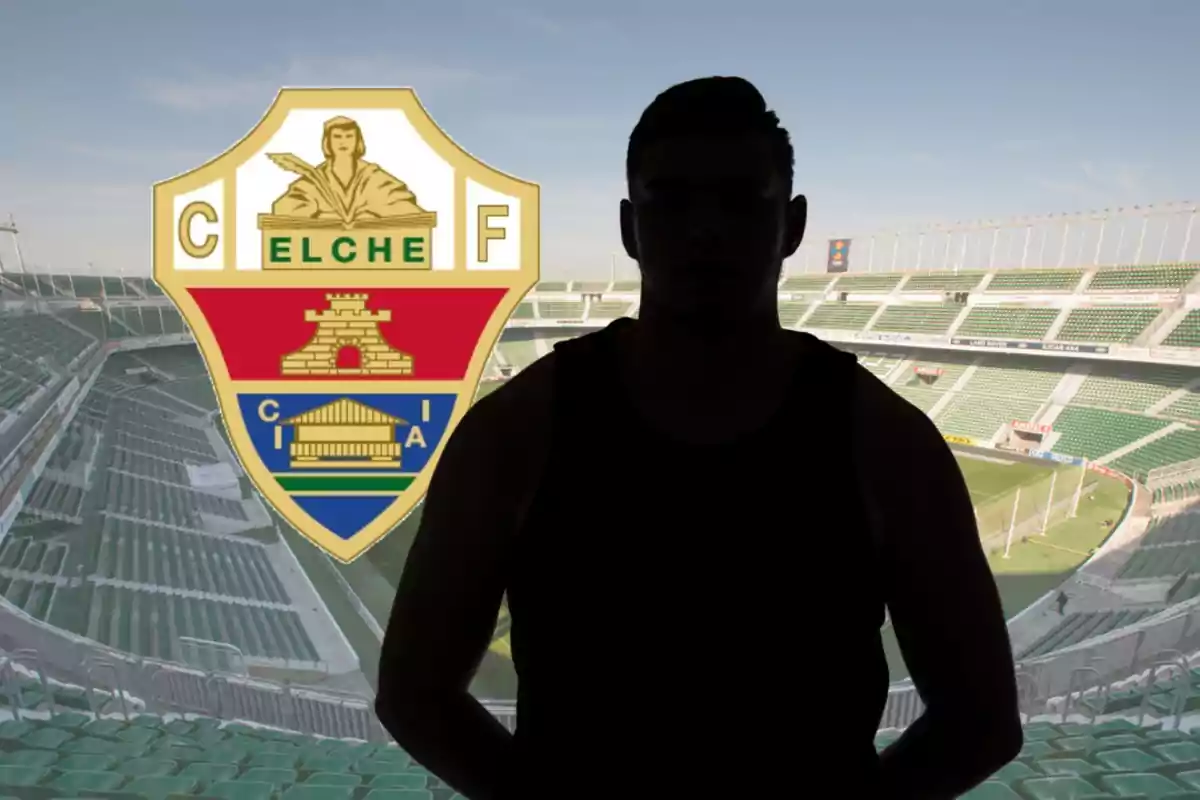 Persona en silueta davant de l’escut de l’Elx CF a l’interior d’un estadi de futbol buit
