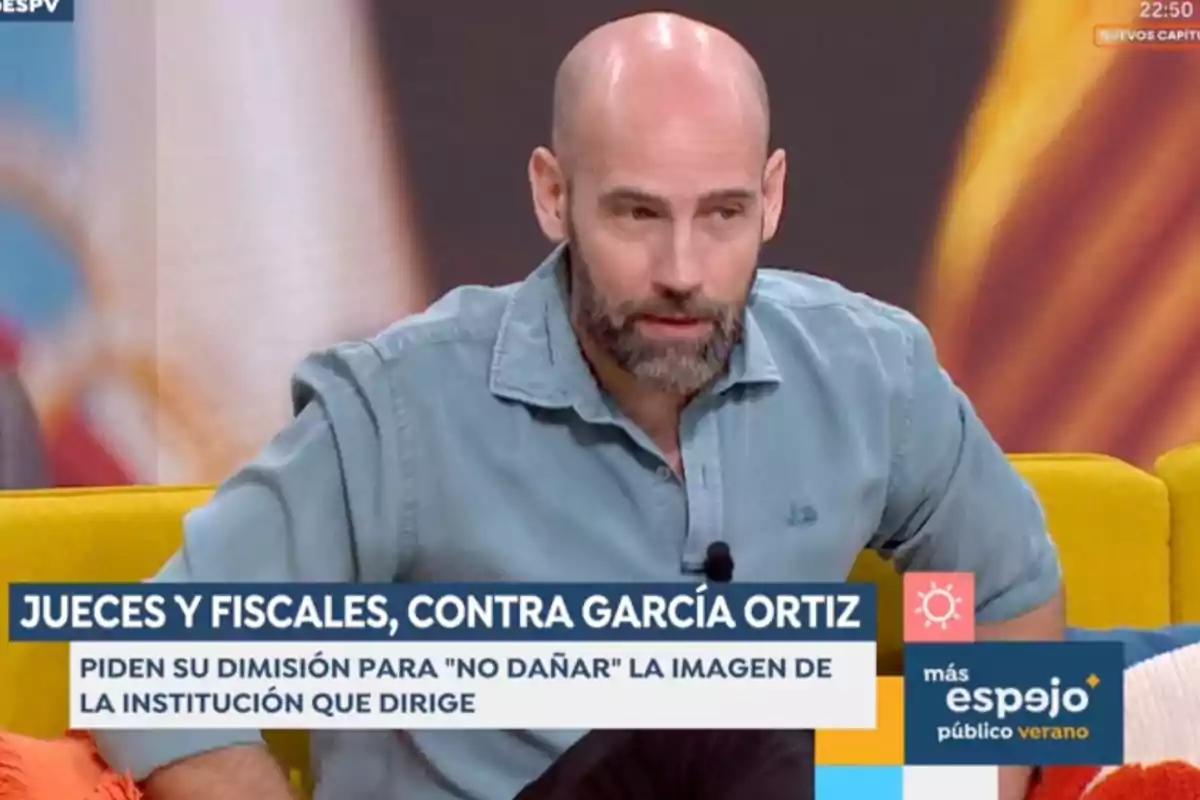 Gonzalo Miró amb camisa blau clar assegut en un sofà groc durant un programa de televisió amb un rètol que informa sobre jutges i fiscals demanant la dimissió de García Ortiz. Captura d’‘Espejo Público’. Gonzalo Miró amb camisa blau clar assegut en un sofà groc durant un programa de televisió amb un rètol que informa sobre jutges i fiscals demanant la dimissió de García Ortiz. Captura d’‘Espejo Público’.