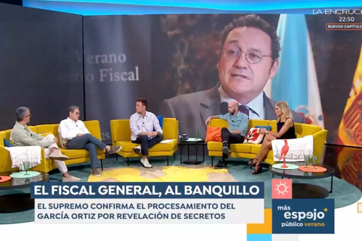 Un grup de quatre persones conversa en un plató de televisió amb butaques grogues i una gran pantalla de fons que mostra el rostre d’un home amb ulleres, mentre a la part inferior apareix un titular sobre el fiscal general i el processament de García Ortiz per revelació de secrets. Captura d’‘Espejo Público’. Un grup de quatre persones conversa en un plató de televisió amb butaques grogues i una gran pantalla de fons que mostra el rostre d’un home amb ulleres, mentre a la part inferior apareix un titular sobre el fiscal general i el processament de García Ortiz per revelació de secrets. Captura d’‘Espejo Público’.