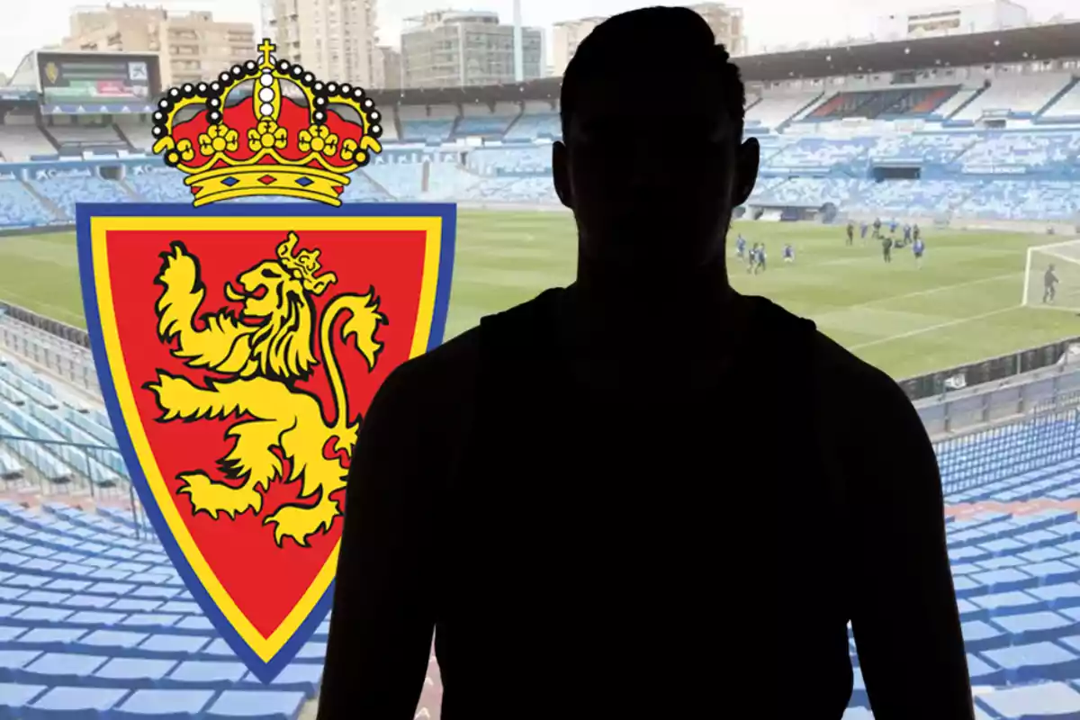 Persona en silueta davant d’un estadi de futbol amb l’escut del Reial Saragossa al fons
