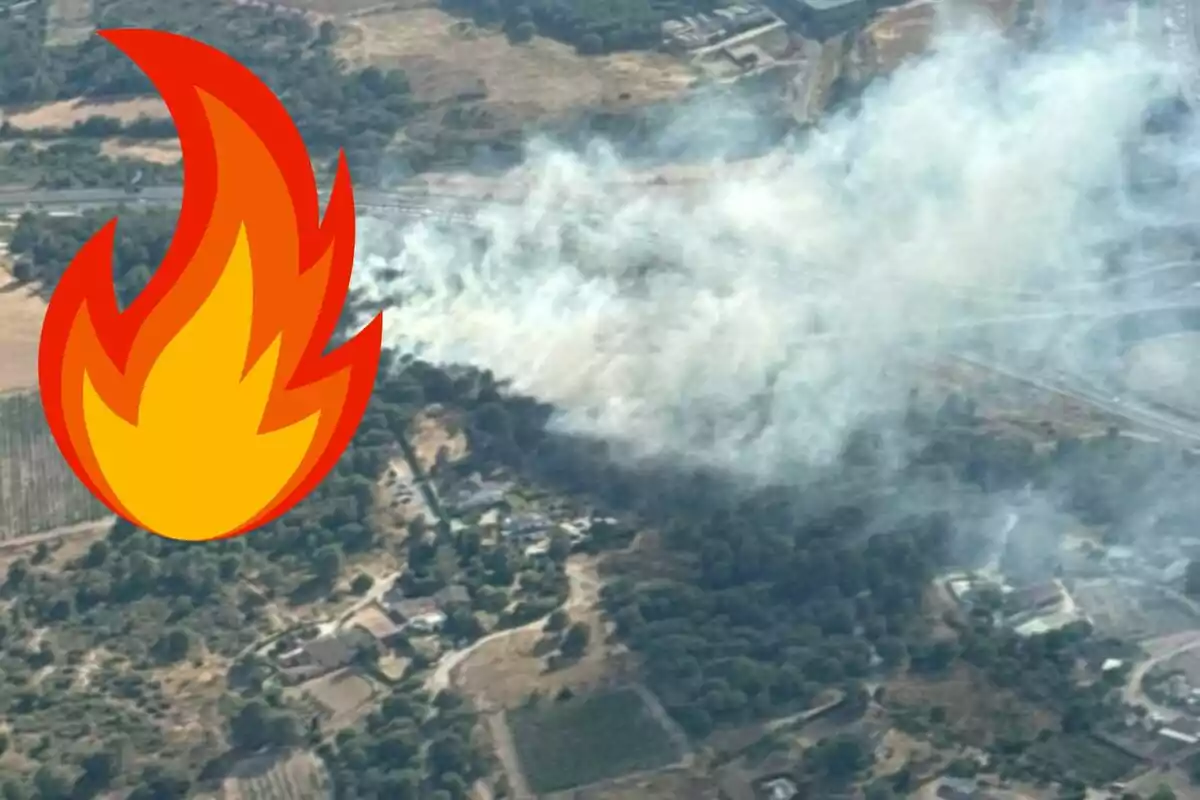 Vista aérea de un incendio forestal con una gran cantidad de humo y un emoji de llama en la esquina izquierda