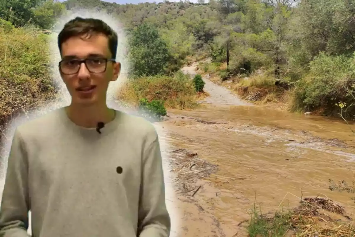 Joven con gafas y micrófono de solapa al frente de un camino rural inundado rodeado de vegetación Joven con gafas y micrófono de solapa al frente de un camino rural inundado rodeado de vegetación