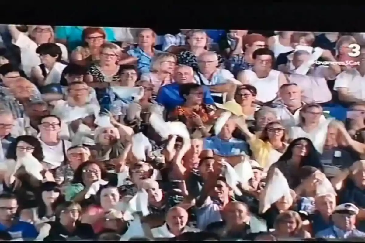 Un grup nombrós de persones a les grades agita mocadors blancs mentre observa un esdeveniment.