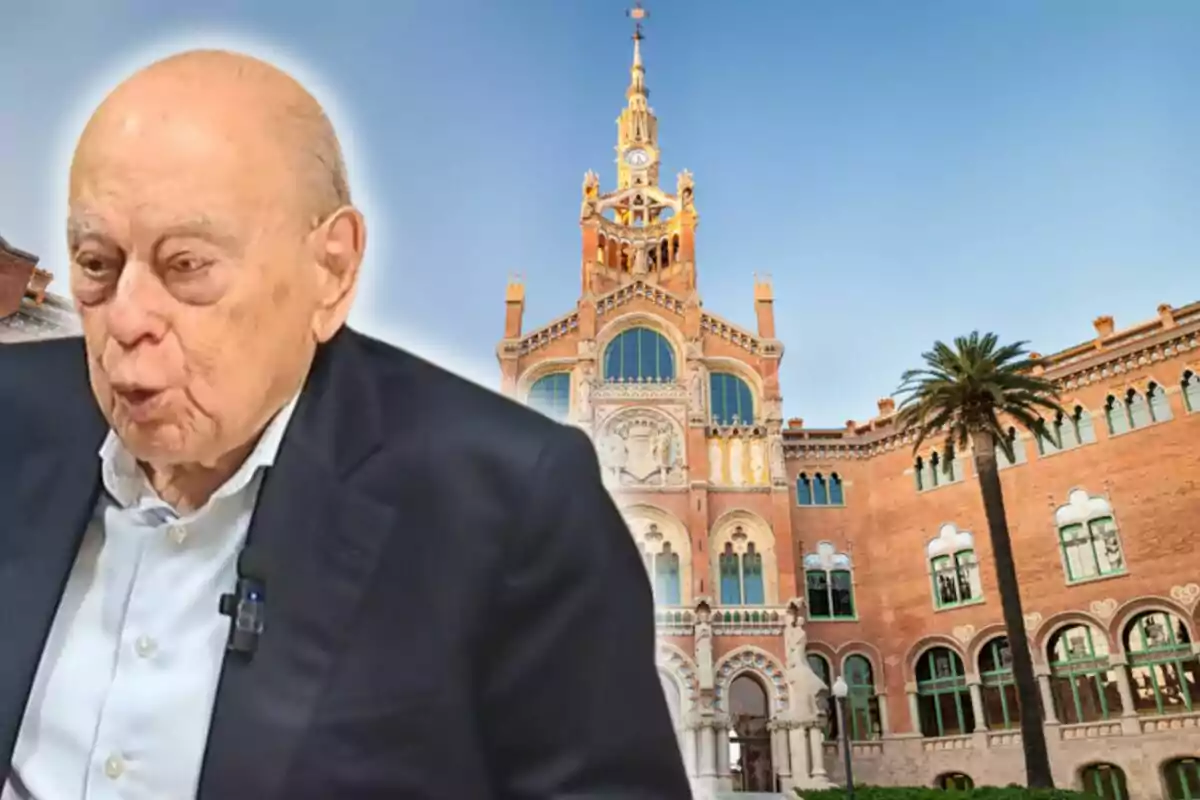 Home gran de cabells canosos i vestit fosc en primer pla amb un edifici històric de maó i una palmera al fons sota un cel serè
