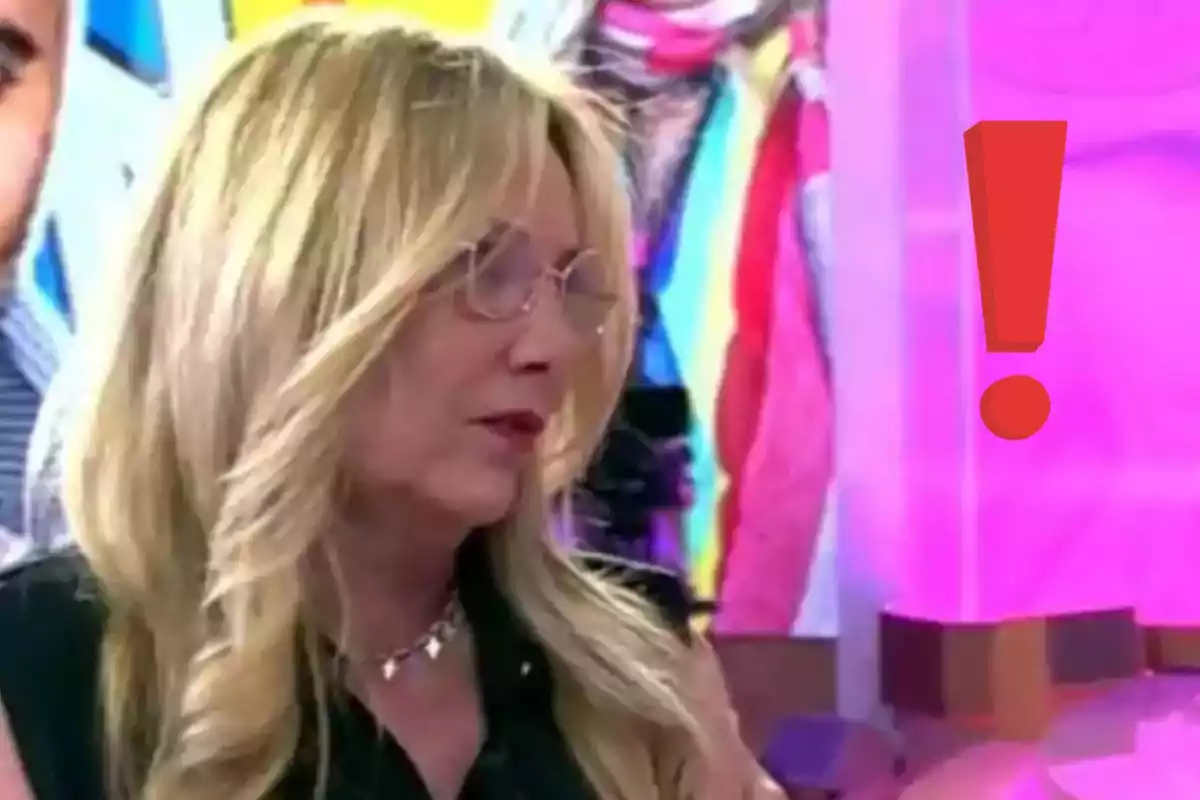 Dona rossa amb ulleres en un plató colorit amb un gran signe d’exclamació vermell a la dreta