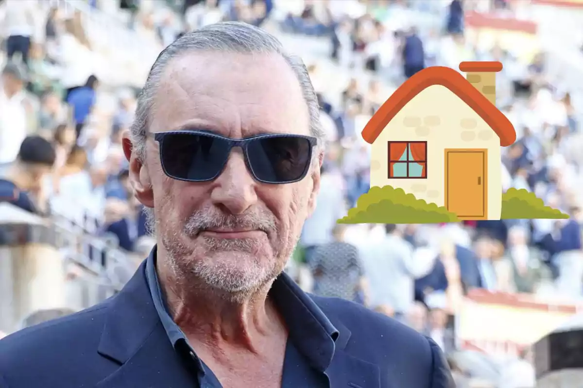 Home de cabells canosos i ulleres fosques amb una casa dibuixada al fons en un lloc concorregut