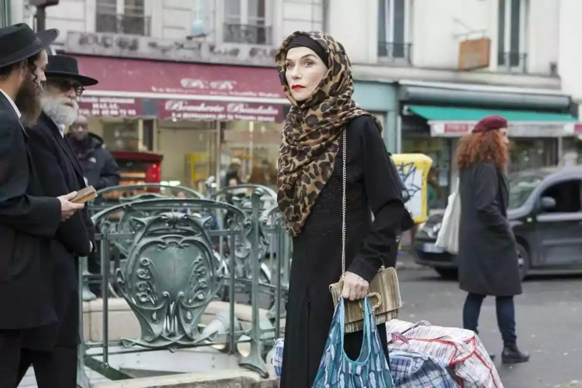 Dona amb hijab d’estampat animal i vestit negre sosté bosses en un carrer concorregut de la ciutat Dona amb hijab d’estampat animal i vestit negre sosté bosses en un carrer concorregut de la ciutat