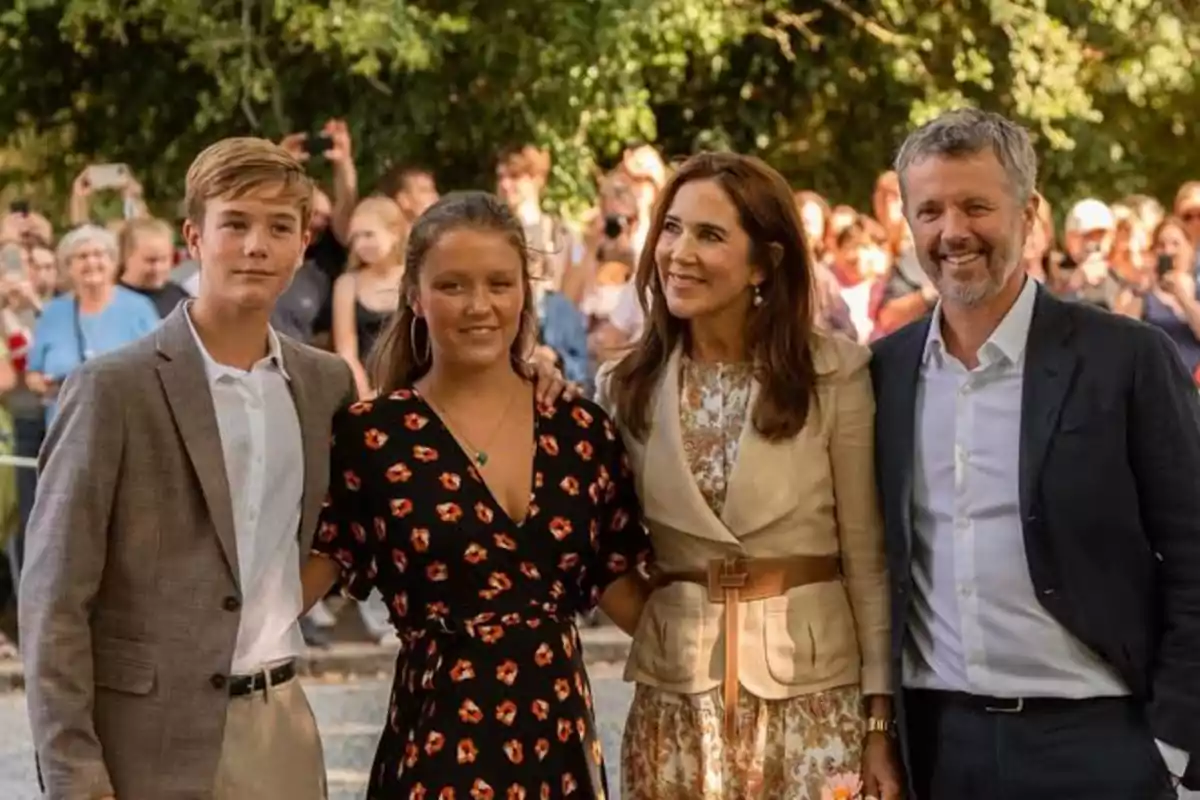 La Familia Real de Dinamarca posa junta al aire libre con árboles y un grupo de gente al fondo La Familia Real de Dinamarca posa junta al aire libre con árboles y un grupo de gente al fondo