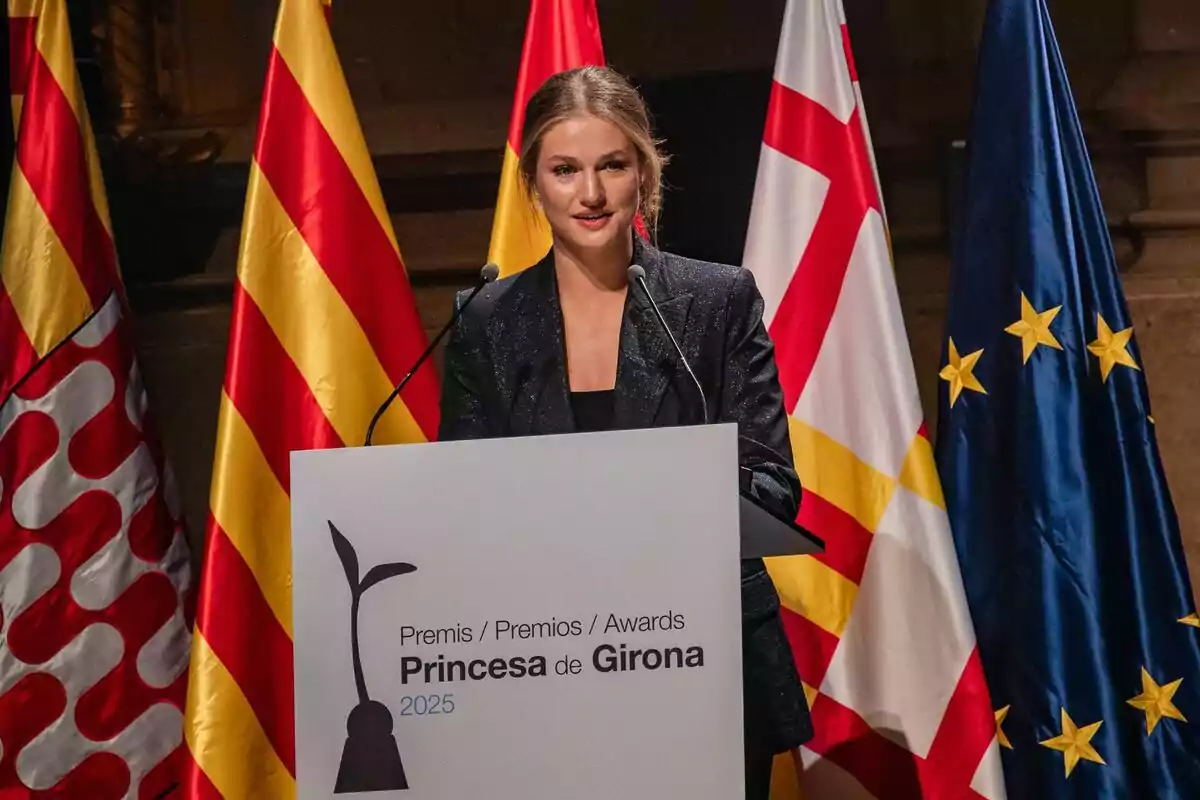 La princesa Leonor con chaqueta oscura habla en un atril durante la ceremonia de los Premios Princesa de Girona 2025 con varias banderas de fondo La princesa Leonor con chaqueta oscura habla en un atril durante la ceremonia de los Premios Princesa de Girona 2025 con varias banderas de fondo