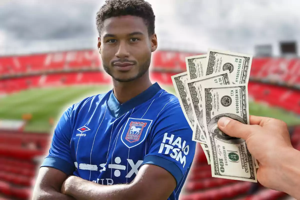 Futbolista con uniforme azul en un estadio y una mano sosteniendo billetes de dólar frente a él Futbolista con uniforme azul en un estadio y una mano sosteniendo billetes de dólar frente a él
