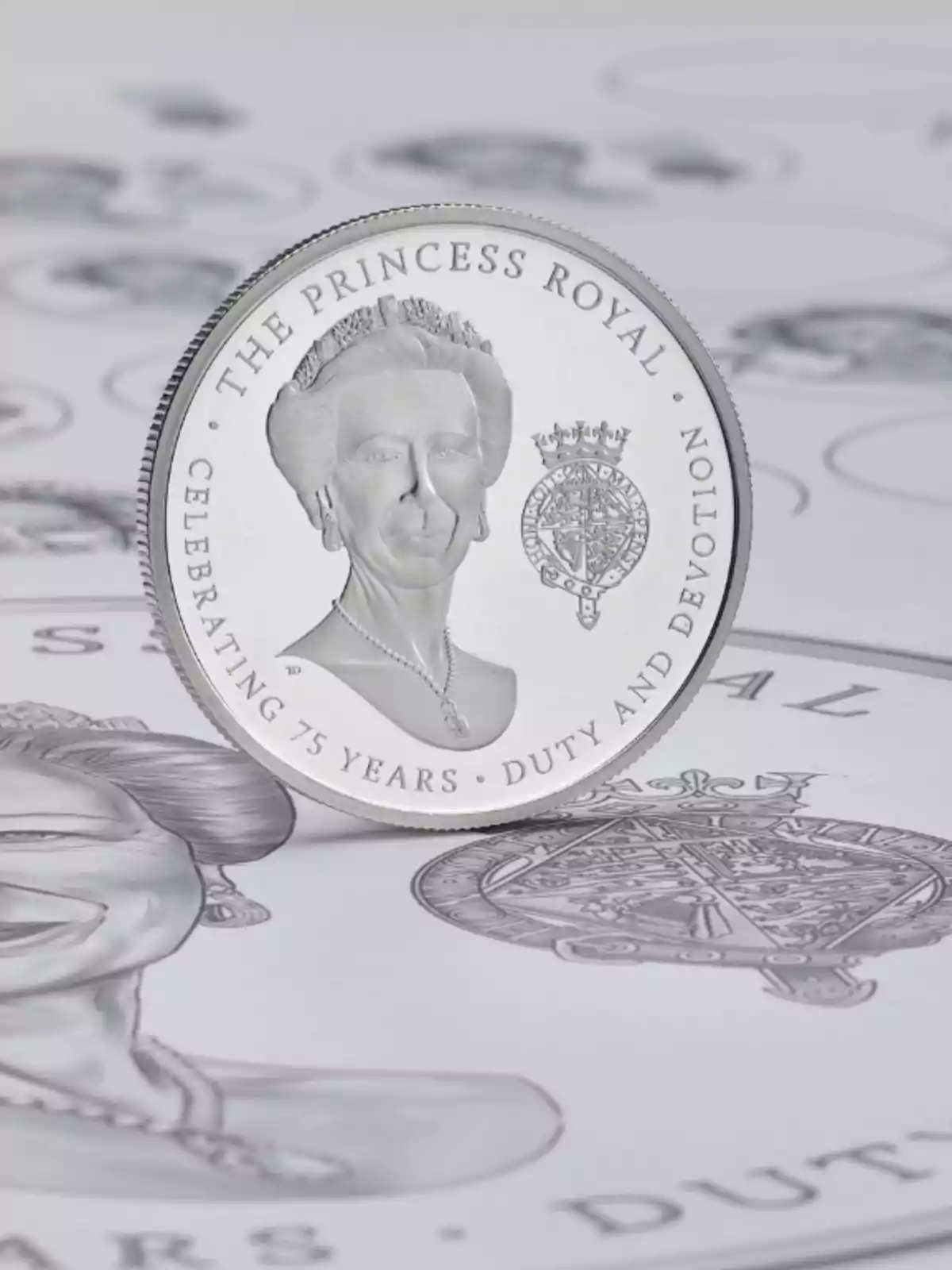 Moneda commemorativa platejada amb el retrat d’una dona i la inscripció The Princess Royal Celebrating 75 Years Duty and Devotion sobre un fons d’il·lustracions similars Moneda commemorativa platejada amb el retrat d’una dona i la inscripció The Princess Royal Celebrating 75 Years Duty and Devotion sobre un fons d’il·lustracions similars