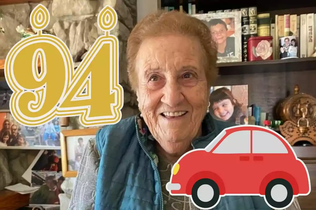 Dona gran somrient amb el número 94 en forma d'espelmes i un dibuix d'un cotxe vermell, en una habitació amb fotos familiars i llibres al fons