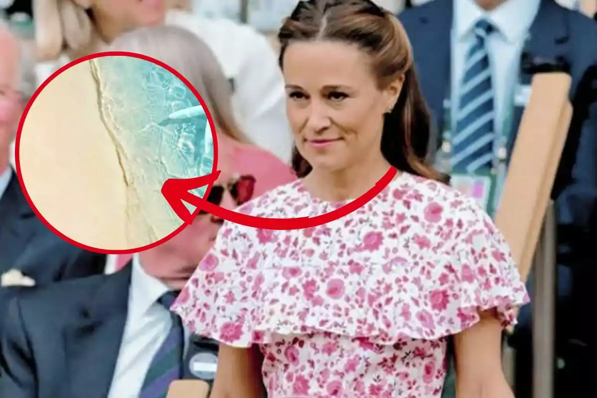 Dona amb vestit de flors rosa en un esdeveniment públic amb un cercle ampliat que mostra una platja amb aigua turquesa i sorra clara assenyalada per una fletxa vermella