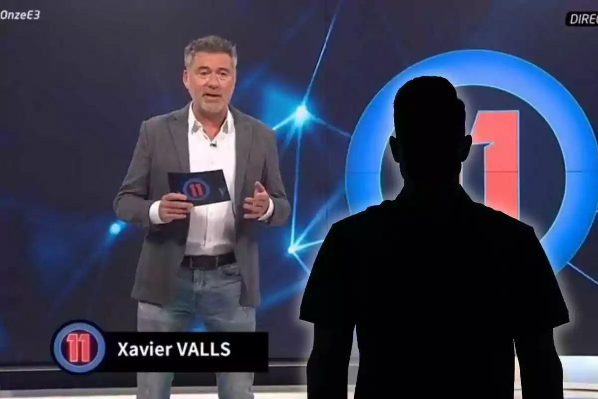 Un presentador de televisió sosté una targeta mentre està dret en un plató modern amb gràfics blaus i el número 11 al fons, acompanyat de la silueta negra d’una persona en primer pla.