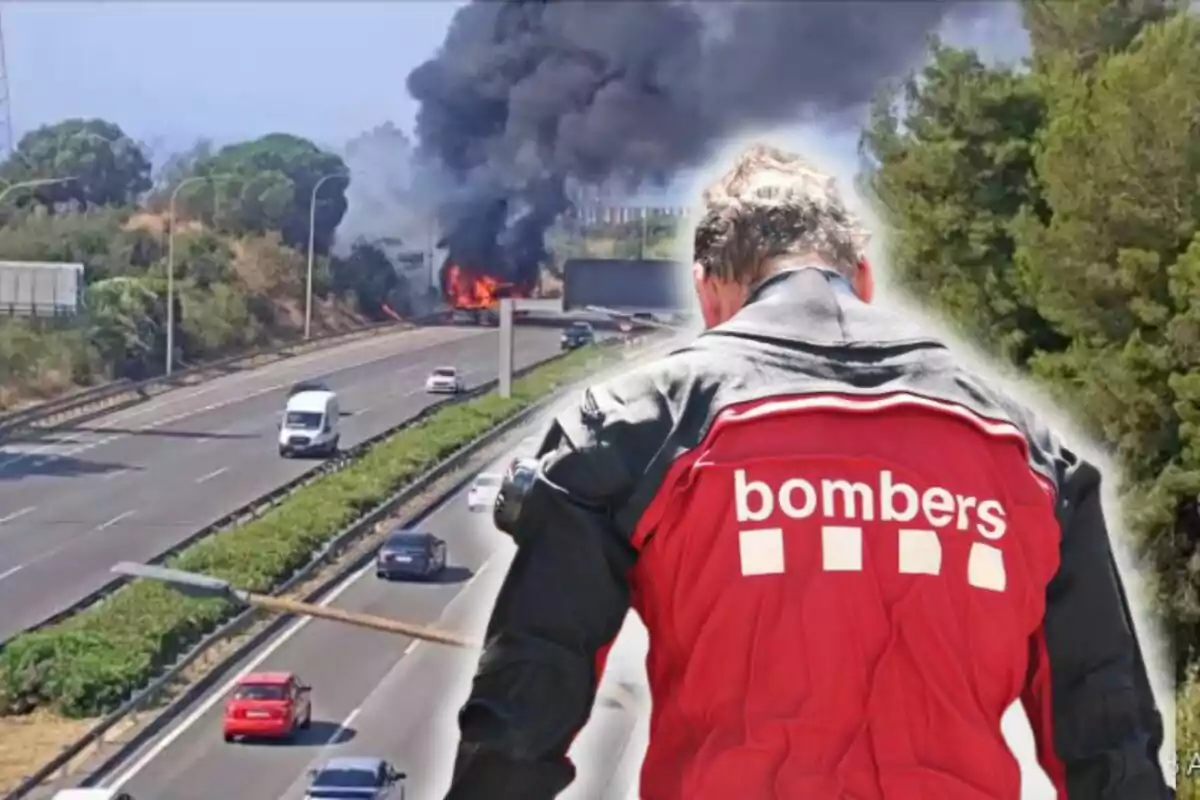 Un bomber d’esquena observa un incendi a l’autopista on un vehicle està envoltat de flames i s’eleva una gran columna de fum negre.