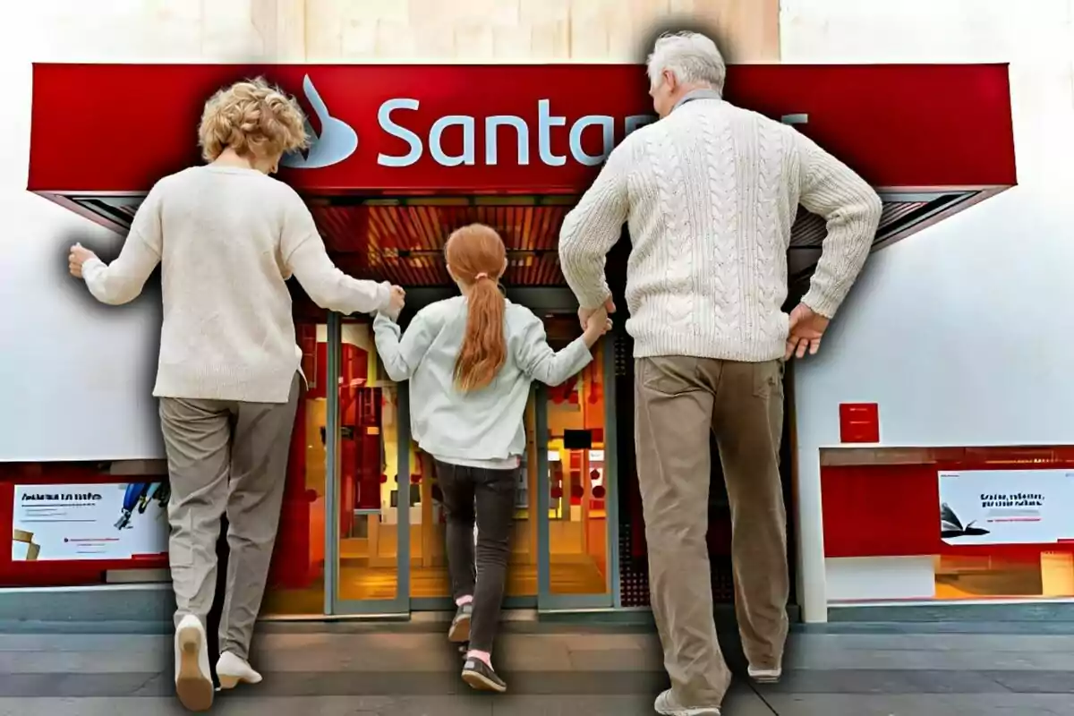 Una parella de persones grans i una nena entren juntes a una sucursal bancària del Santander.