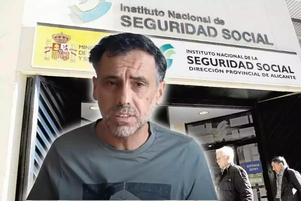 Un home de cabell curt i barba apareix en primer pla davant de l’entrada de l’Institut Nacional de la Seguretat Social a Alacant mentre dues persones grans surten de l’edifici.
