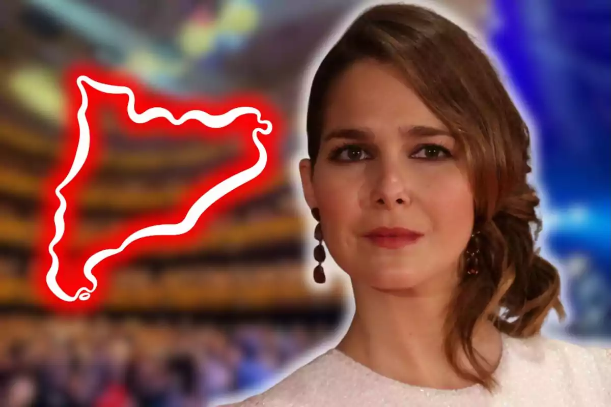 Dona de cabells castanys amb vestit blanc posant davant d’un fons desenfocat amb la silueta de Catalunya ressaltada en vermell al seu costat.