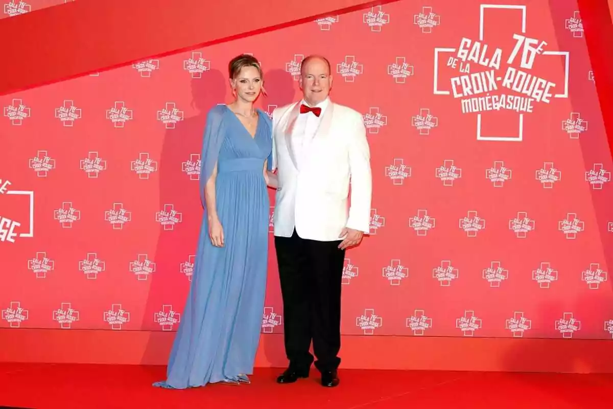 Charlene i Albert de Mònaco, elegantment vestits, posen sobre una catifa vermella davant d’un fons amb logotips de la Gala de la Creu Roja Monegasca. Charlene i Albert de Mònaco, elegantment vestits, posen sobre una catifa vermella davant d’un fons amb logotips de la Gala de la Creu Roja Monegasca.