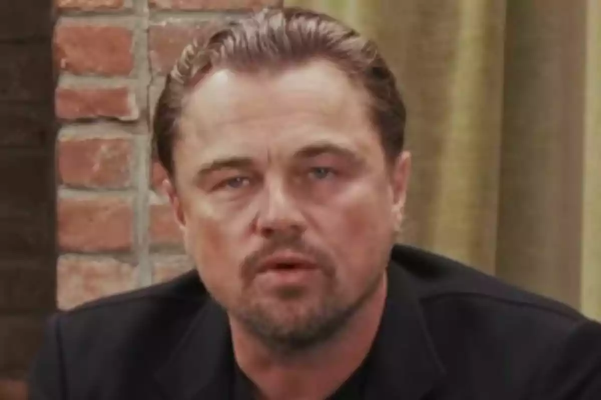 Close-up of Leonardo DiCaprio with a serious expression, brick wall background and green curtain. Close-up of Leonardo DiCaprio with a serious expression, brick wall background and green curtain.