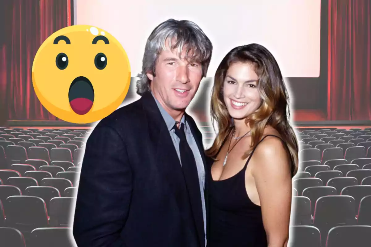 Parella posant somrient en una sala de cinema amb un emoji de sorpresa gran al fons