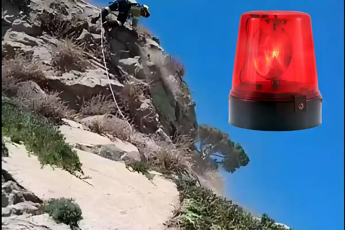 Persona descendiendo por una cuerda en una ladera rocosa con vegetación y un fondo azul, junto a una sirena de emergencia roja en la parte superior derecha