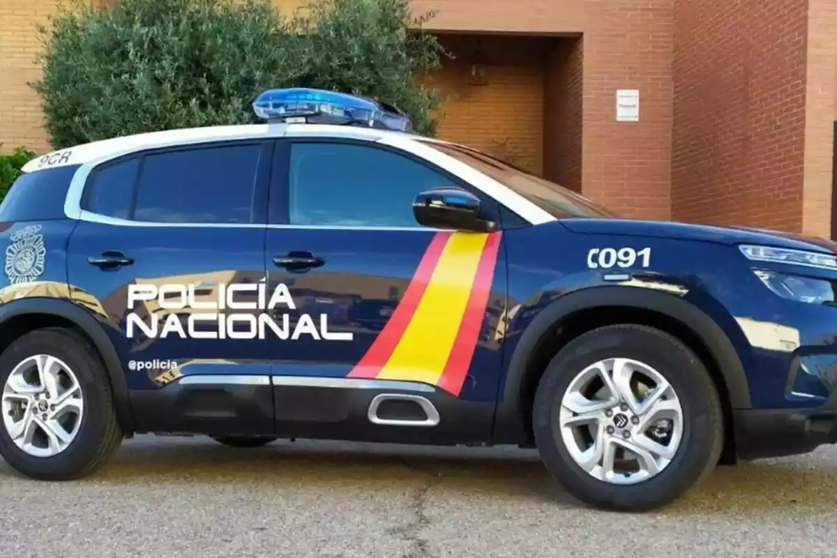Cotxe patrulla de la Policia Nacional d’Espanya estacionat al costat d’un edifici de maó Cotxe patrulla de la Policia Nacional d’Espanya estacionat al costat d’un edifici de maó