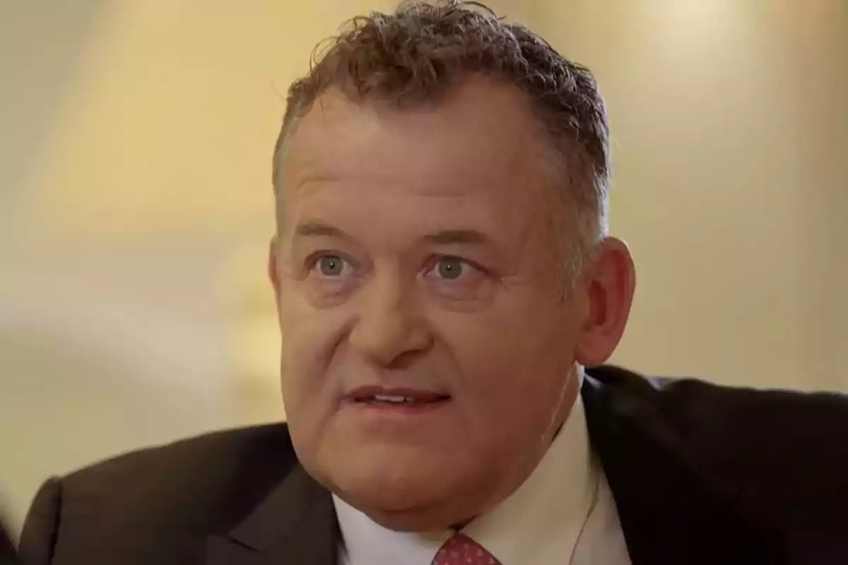 Paul Burrell con traje oscuro y corbata rosa mirando hacia el frente con expresión seria. Captura de 'Viajando con Chester' Paul Burrell con traje oscuro y corbata rosa mirando hacia el frente con expresión seria. Captura de 'Viajando con Chester'
