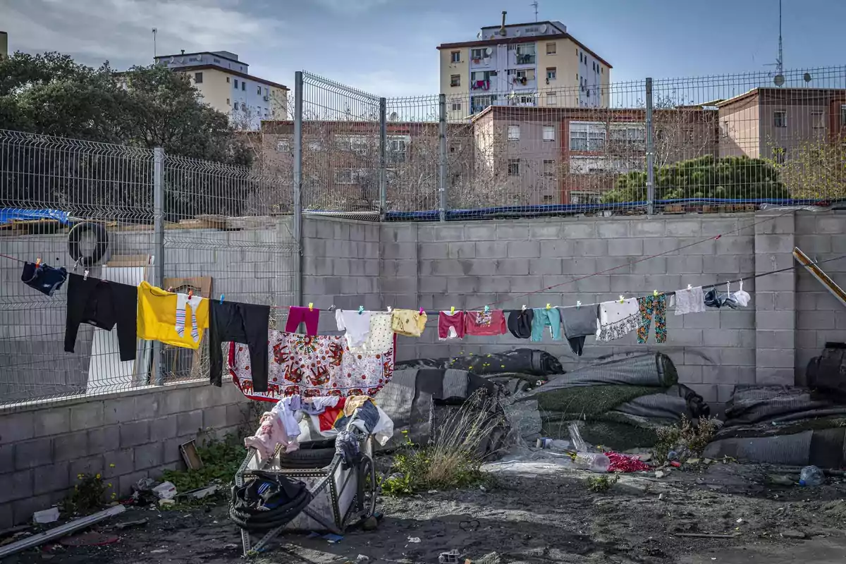 Ropa de diferentes colores colgada en un tendedero en un terreno descuidado con edificios de apartamentos al fondo Ropa de diferentes colores colgada en un tendedero en un terreno descuidado con edificios de apartamentos al fondo