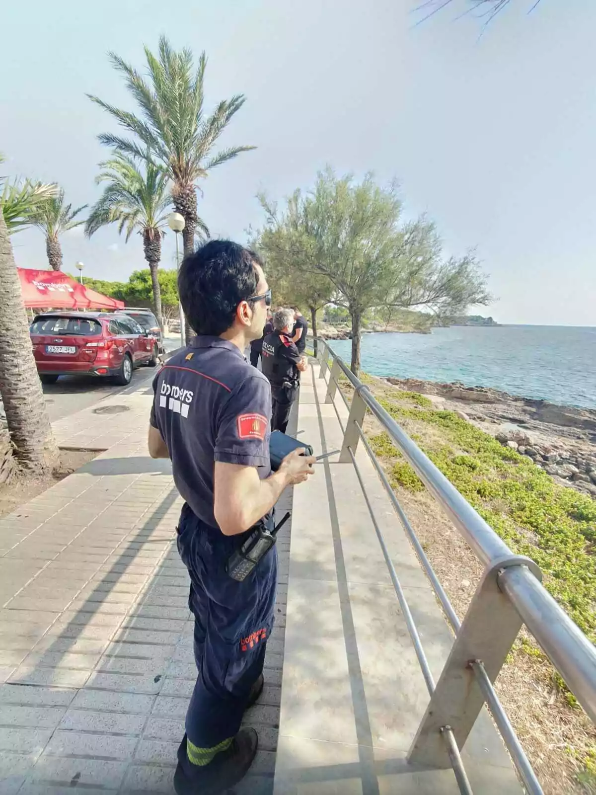 Un agent dels Bombers treballant amb un dron a la platja de l'Ametlla de Mar
